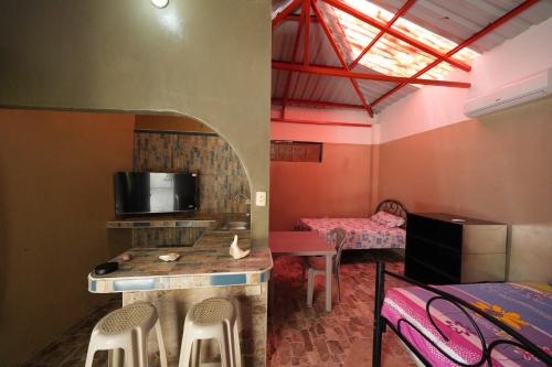 a small room with a bed and a table and chairs at HostaSuites Mijinn in Playas