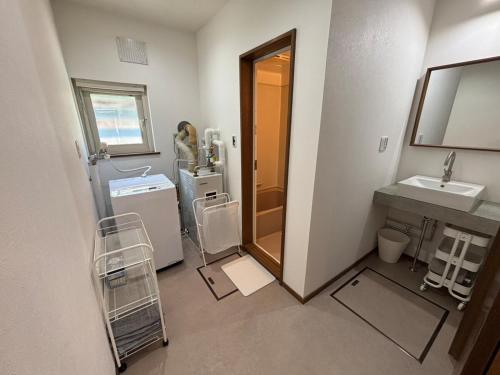 een kleine badkamer met een wastafel en een spiegel bij Kamui Adventure House in Asahikawa