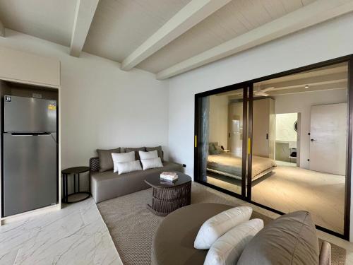 a living room with a couch and a refrigerator at Beachside Residence in Koh Samui