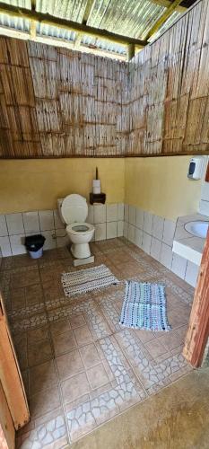 a bathroom with a toilet and a sink at Cabinas Paraíso Corcovado in Drake