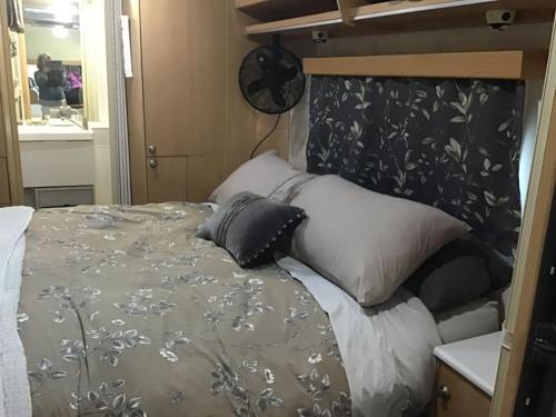 a bedroom with a bed with a black and gray blanket at Redwood Valley B and B Caravan Retreat in Redwoods Valley
