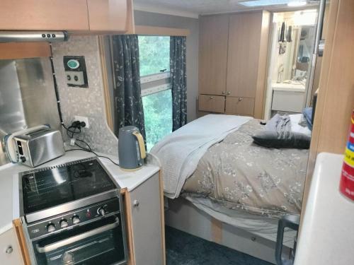a small room with a bed and a kitchen at Redwood Valley B and B Caravan Retreat in Redwoods Valley