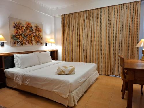 a hotel room with a bed with a desk and a desk at The Palmana Courtyard Jayakarta Residence 6 in Seminyak