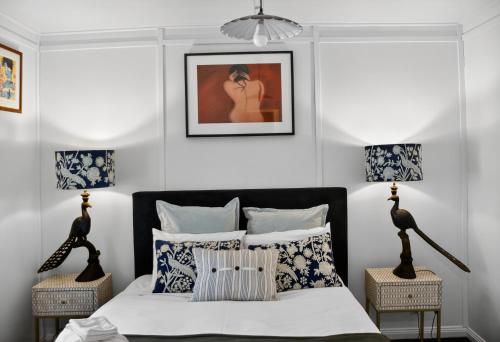 ein Schlafzimmer mit einem Bett mit blauen und weißen Kissen in der Unterkunft Cedar Cottage Daylesford in Daylesford
