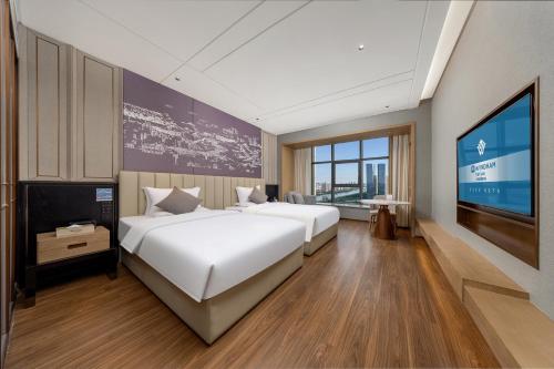 a bedroom with two beds and a flat screen tv at WYNDHAM TAIYUAN in Taiyuan