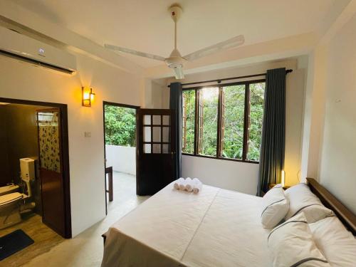 ゴールにあるTropicana Terraceの大きなベッドと大きな窓のある寝室