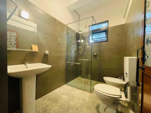 ゴールにあるTropicana Terraceのトイレ、洗面台、シャワー付きのバスルーム