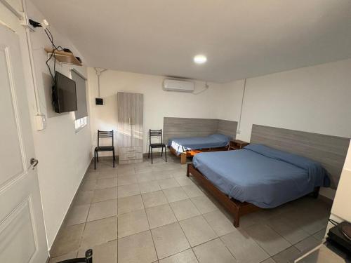 a bedroom with two beds and a table and chairs at Departamento Chacabuco in San Fernando del Valle de Catamarca