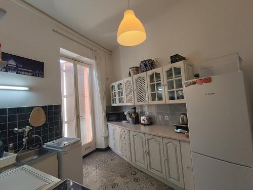 a kitchen with white cabinets and a white refrigerator at Romantic Studio Center in Colmar