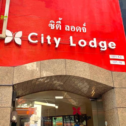 a store with a red sign on the side of a building at City Lodge Bangkok in Bangkok