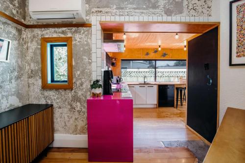 a kitchen with a pink counter in a room at Fun Times in Fitzroy - eclectic bungalow by beach in New Plymouth