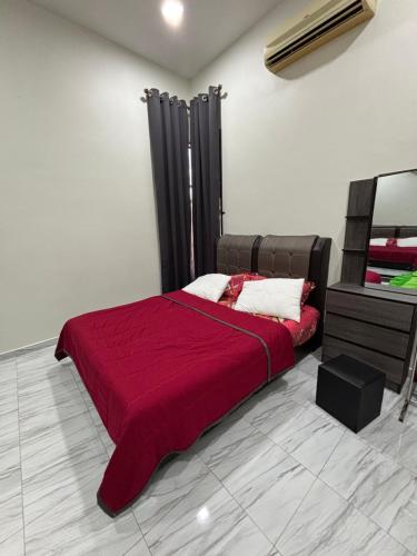 a bedroom with a bed with a red blanket at D Bukit homestay in Ketereh