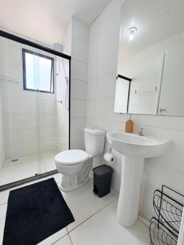 ein weißes Badezimmer mit Toilette und Waschbecken in der Unterkunft Apê moderno perto do shopping - WI-FI rápido e garagem in Caruaru