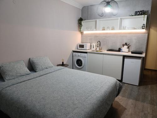 a bedroom with a bed and a kitchen with a microwave at Beach apartment's in Limassol