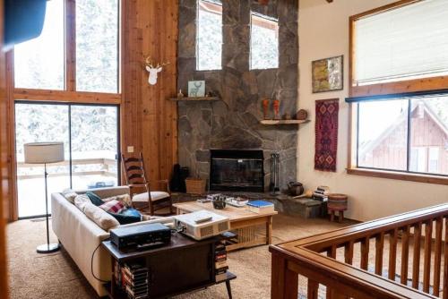 un salon avec un canapé et une cheminée dans l'établissement Blue Jay's Nest Sequoia Cabin in Ponderosa, CA, à Ponderosa