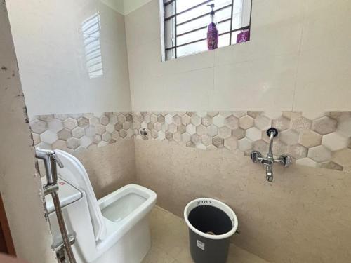 een badkamer met toilet, wastafel en raam bij Ideal 2BHK for Families & Work Trips in Bangalore