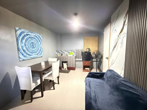 a dining room with a table and white chairs at Bloom&Blossom in Iloilo City