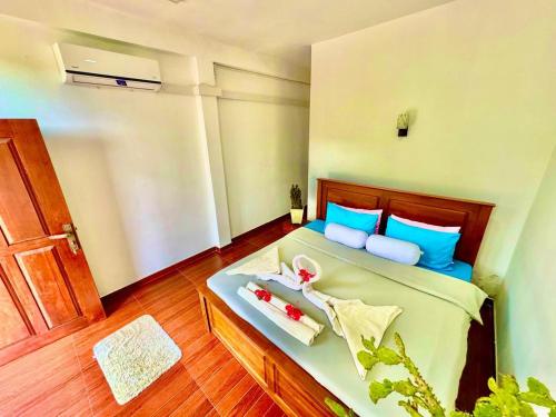 a bed with blue pillows and a tray of food on it at The Ceylan Crest ELLA in Ella