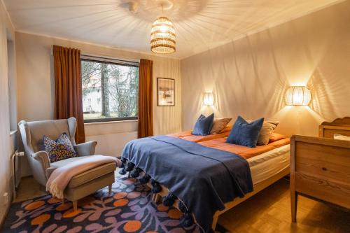 a bedroom with a bed and a chair and a window at Villa Amara & Private Spa in Rovaniemi