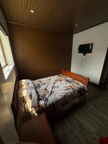een slaapkamer met een bed in een kamer met een televisie bij Departamento Campestre in Ibarra