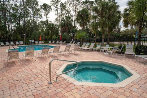 基西米Disney Magic Condo 1st Flr 3BR Disney-Themed Pool的一个带椅子和桌子的游泳池，以及一个泳池设施