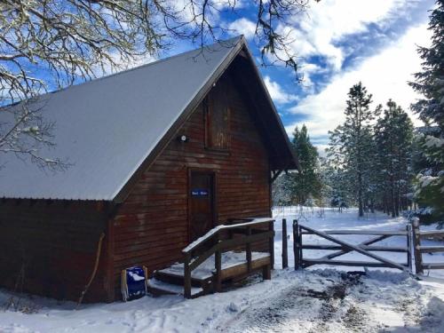 un pequeño granero de madera con nieve en el suelo en Rustic Cabin Rental in a Wild Meadow near Crater Lake National Park, Oregon, en Prospect