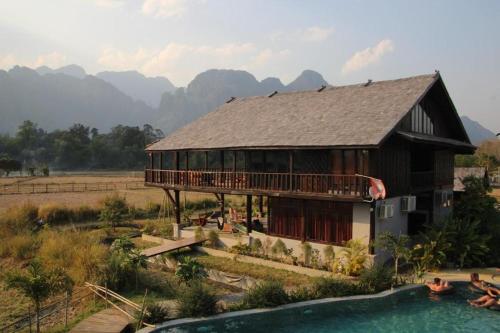a house with a swimming pool in front of it at Dalasone Pool Villas with Stunning Mountain Views in Vang Vieng