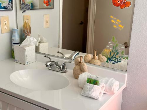 基西米Disney Magic Condo 1st Flr 3BR Disney-Themed Pool的浴室里有洗手池和镜子