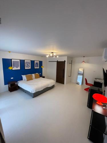 a bedroom with a bed and a blue wall at The Lamoon Residence samui in Lamai