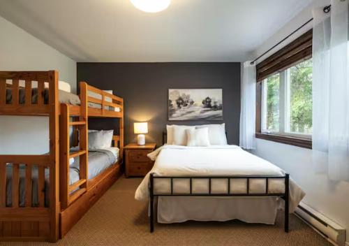 een slaapkamer met twee stapelbedden en een raam bij Tremblant Classic Chalet La Bête Golf Course in Mont-Tremblant