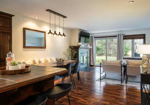 een keuken en woonkamer met een tafel en stoelen bij Tremblant Classic Chalet La Bête Golf Course in Mont-Tremblant