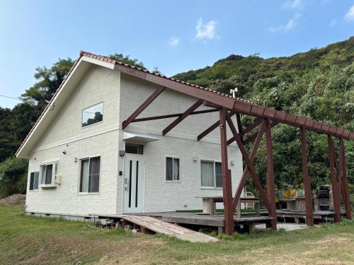 a house with a wooden frame in front of it at ゼロベース下関室津 in Kogushi