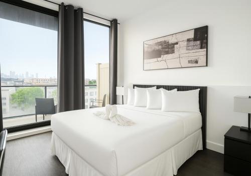 a bedroom with a large white bed and a large window at Nova Hotel Brooklyn in Brooklyn