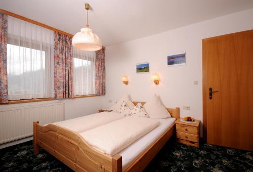 ein Schlafzimmer mit einem großen Bett und einem Fenster in der Unterkunft Haus Leonhard in Tux