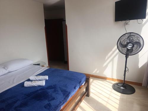 a bedroom with a bed with a fan and a fan at comfort house san gil in San Gil