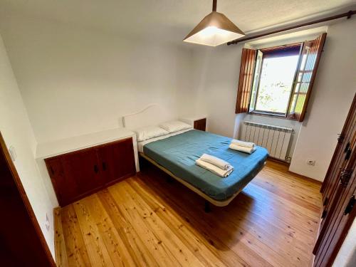 a small bedroom with a bed and a window at Casa do Reguengo (New!) in Castelo de Vide