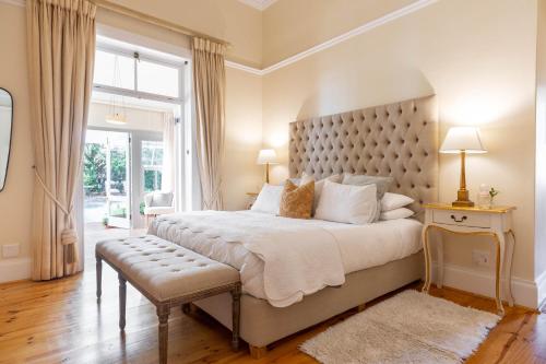 a bedroom with a large bed and a large window at Villa Puccini in Cape Town