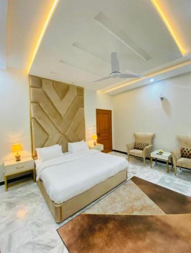a bedroom with a large white bed and a couch at Holiday Inn islamabad in Islamabad