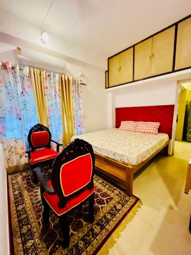 Un dormitorio con una cama y dos sillas. en The Divine Abode Homestay, en Guwahati