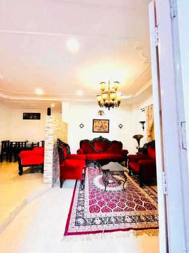 sala de estar con sofás rojos y chimenea en The Divine Abode Homestay, en Guwahati