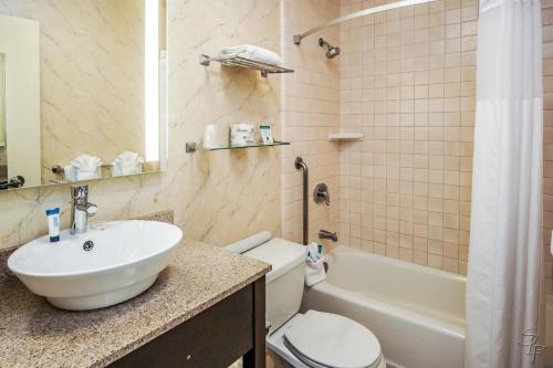 a bathroom with a sink and a toilet and a tub at Red Lion Hotel Monterey in Monterey