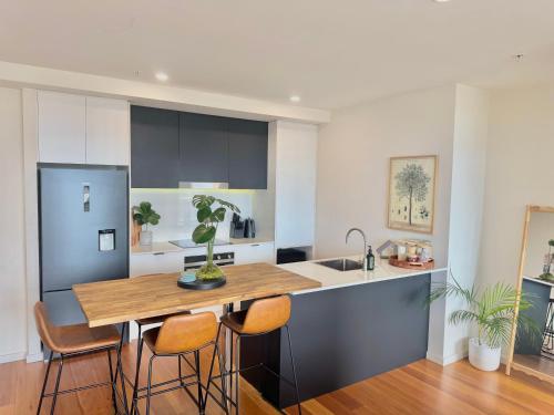 a kitchen with a wooden table and chairs at Harbour Towers, Newcastle's Elite Apartment Stays, Free Parking & Tram Access in Newcastle