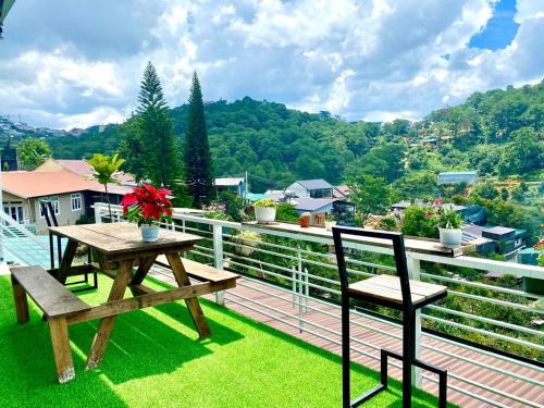 a picnic table and chairs on a balcony with a view at Roxie home view thung lũng,săn mây, gần trung tâm in Xuan An