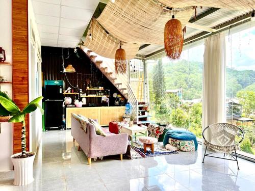 a living room with a large window and a staircase at Roxie home view thung lũng,săn mây, gần trung tâm in Xuan An