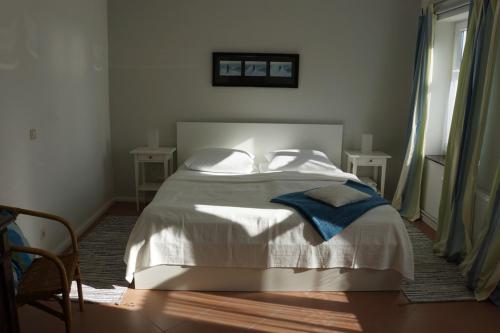 a bedroom with a bed with white sheets and pillows at Haus Buddenbrock auf Rügen in Wiek auf Rügen 