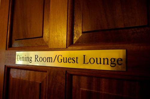 a sign on a wooden door with the words dining room guest lounge at Bunratty Meadows Bed & Breakfast in Bunratty
