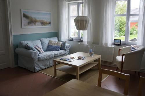 a living room with a couch and a table at Haus Buddenbrock auf Rügen in Wiek auf Rügen 