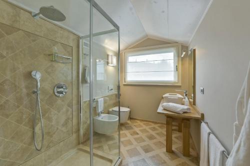 a bathroom with a shower and a toilet and a sink at Villa Vitae in Castiglione Falletto