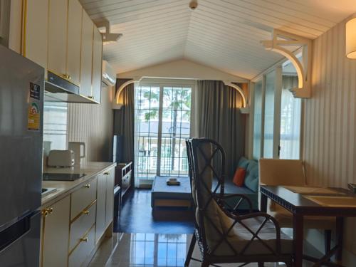 a kitchen with a table and chairs in a room at Grand Florida芭提雅带免费游泳池温泉和健身房和办公区水上花园公寓E208 in Na Jomtien