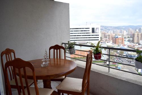 a table and chairs on a balcony with a view of a city at Departamentos Alto Libertad in Viña del Mar